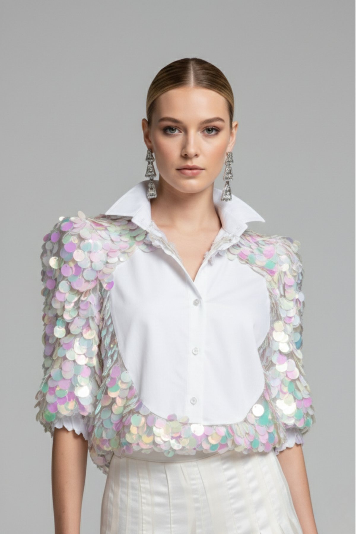Modelo luciendo blusa Sparkling blanca con panel frontal de popelina y mangas 3/4 de tul con lentejuelas multicolor aplicadas a mano | Claudia Bertolero