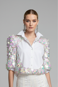 Modelo luciendo blusa Sparkling blanca con panel frontal de popelina y mangas 3/4 de tul con lentejuelas multicolor aplicadas a mano | Claudia Bertolero