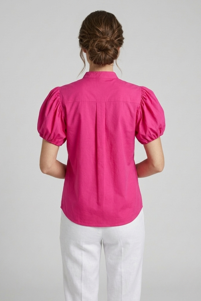 Modelo con blusa Balloon fucsia de algodón con mangas cortas estilo globo y cuello alto con botones invisibles | Claudia Bertolero