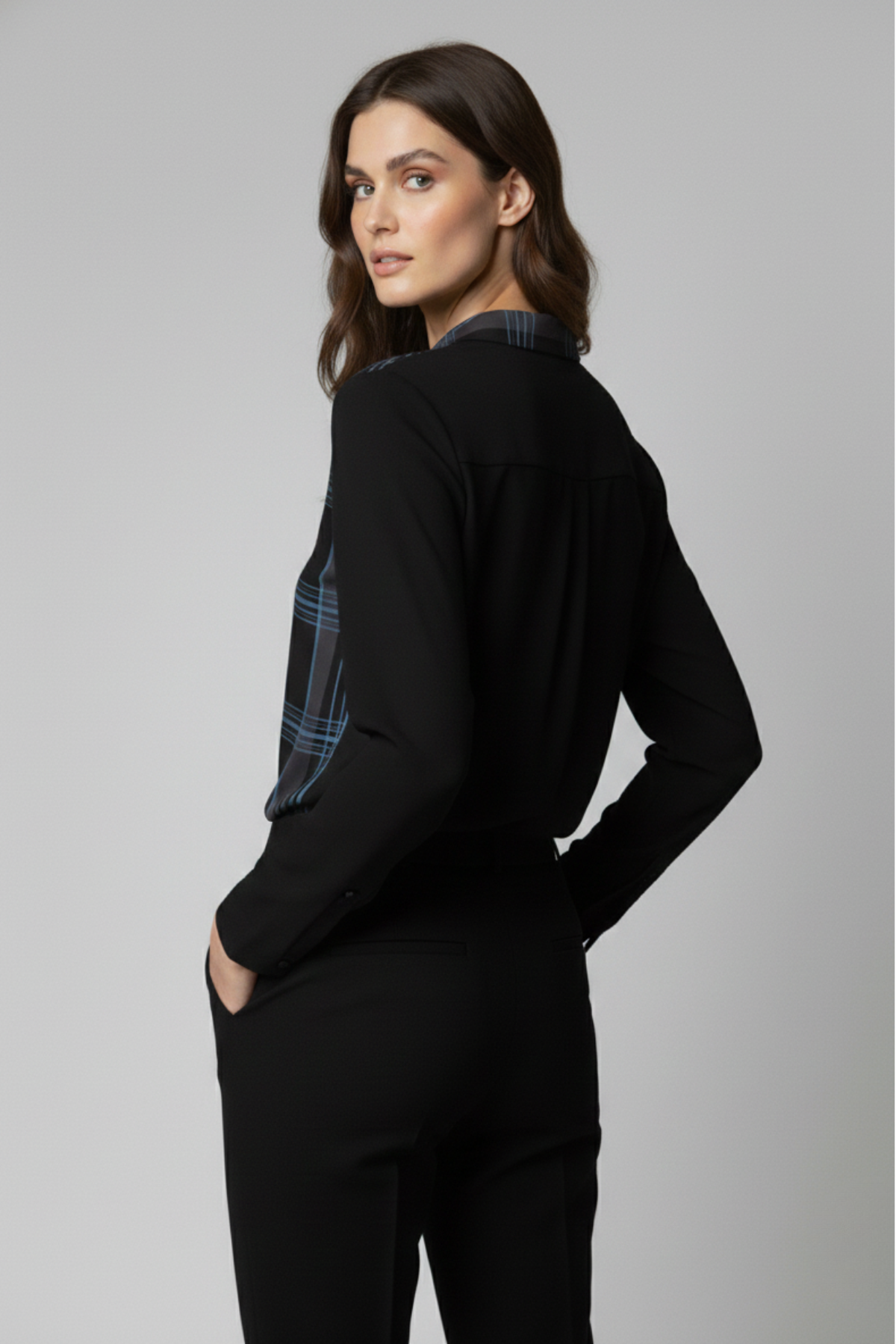 Vista posterior de la Blusa Renoir con panel frontal negro con líneas azules y espalda lisa negra. La imagen destaca el contraste del diseño y la caída fluida de la prenda | Claudia Bertolero