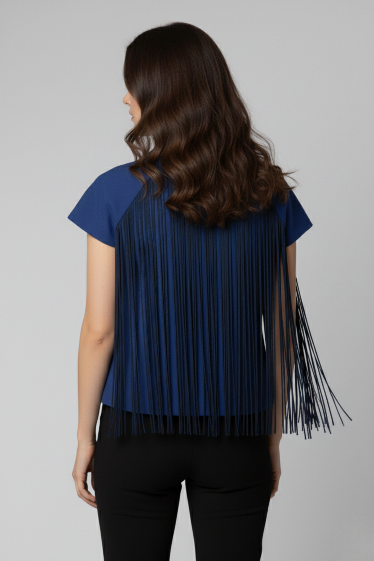 Vista posterior del bolero Batsheva azul con flecos largos que cubren toda la espalda, aportando dinamismo al diseño | Claudia Bertolero