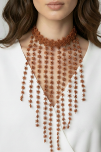 Collar Mi Encanto con flores tejidas en hilo de cobre y uniones en plata 950 con caída decorativa sobre el escote | Claudia Bertolero