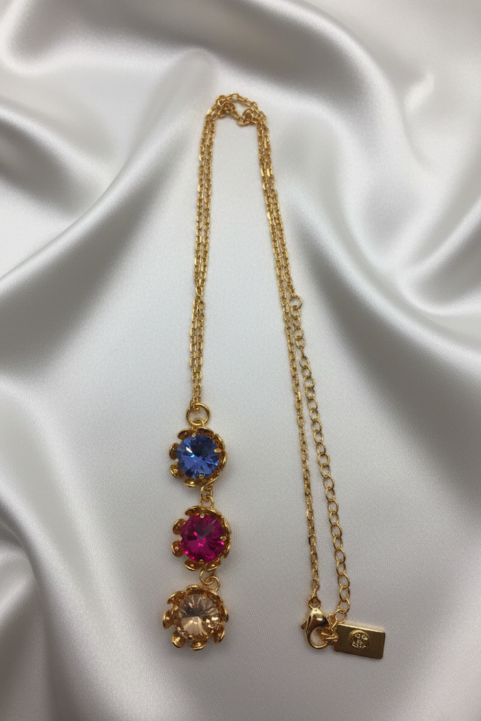 Collar Monnaluna en filigrana bañada en oro con tres cristales Swarovski de colores sobre fondo claro | Claudia Bertolero