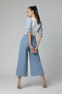 Pantalón Zara celeste en gabardina light con pierna amplia y diseño contemporáneo, combinado con blusa de mangas abullonadas, vista tres cuartos | Claudia Bertolero