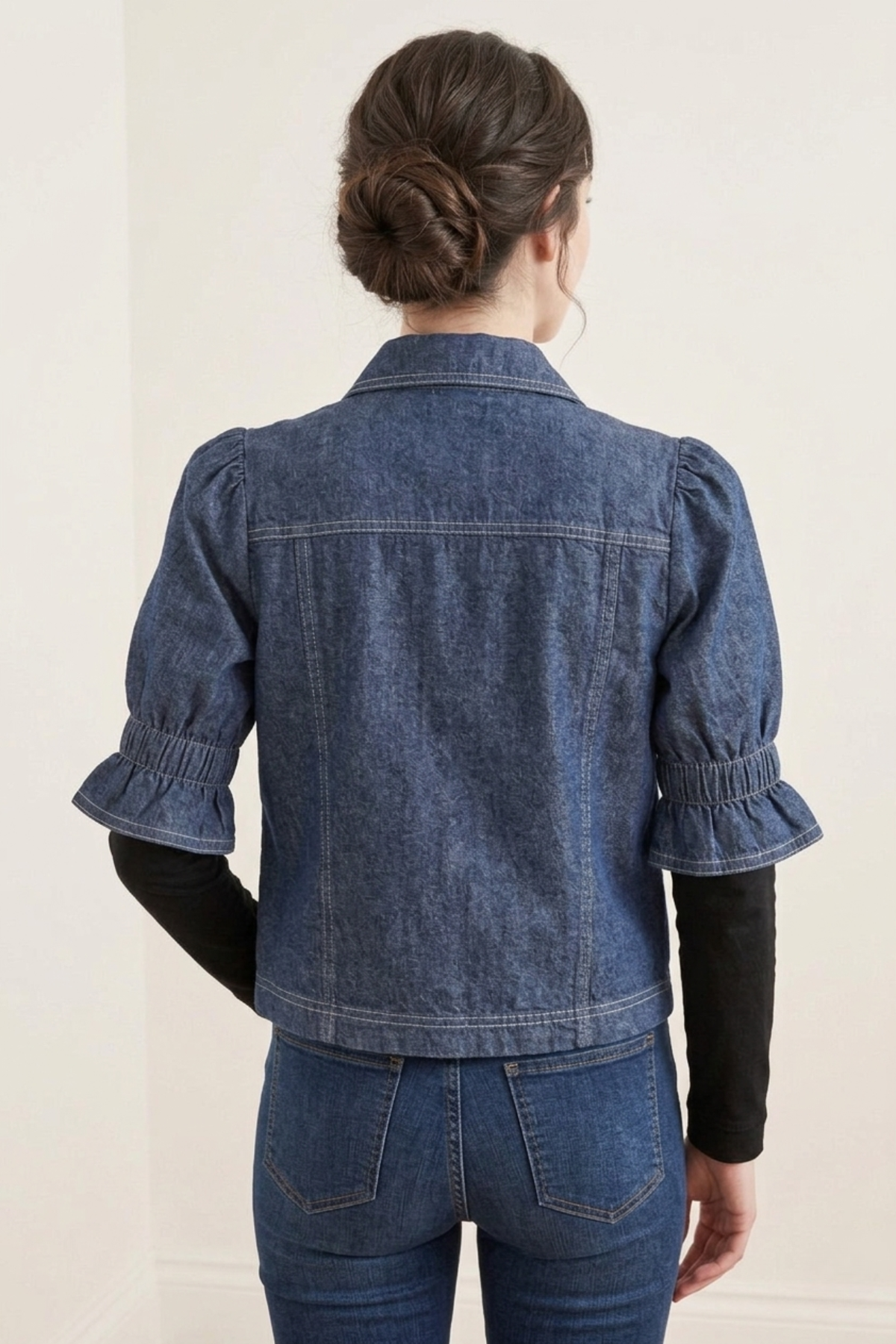Vista posterior de la Casaca Campo en denim azul con mangas cortas estilo balloon y diseño limpio sin bolsillos, combinada con pantalón de jean | Claudia Bertolero
