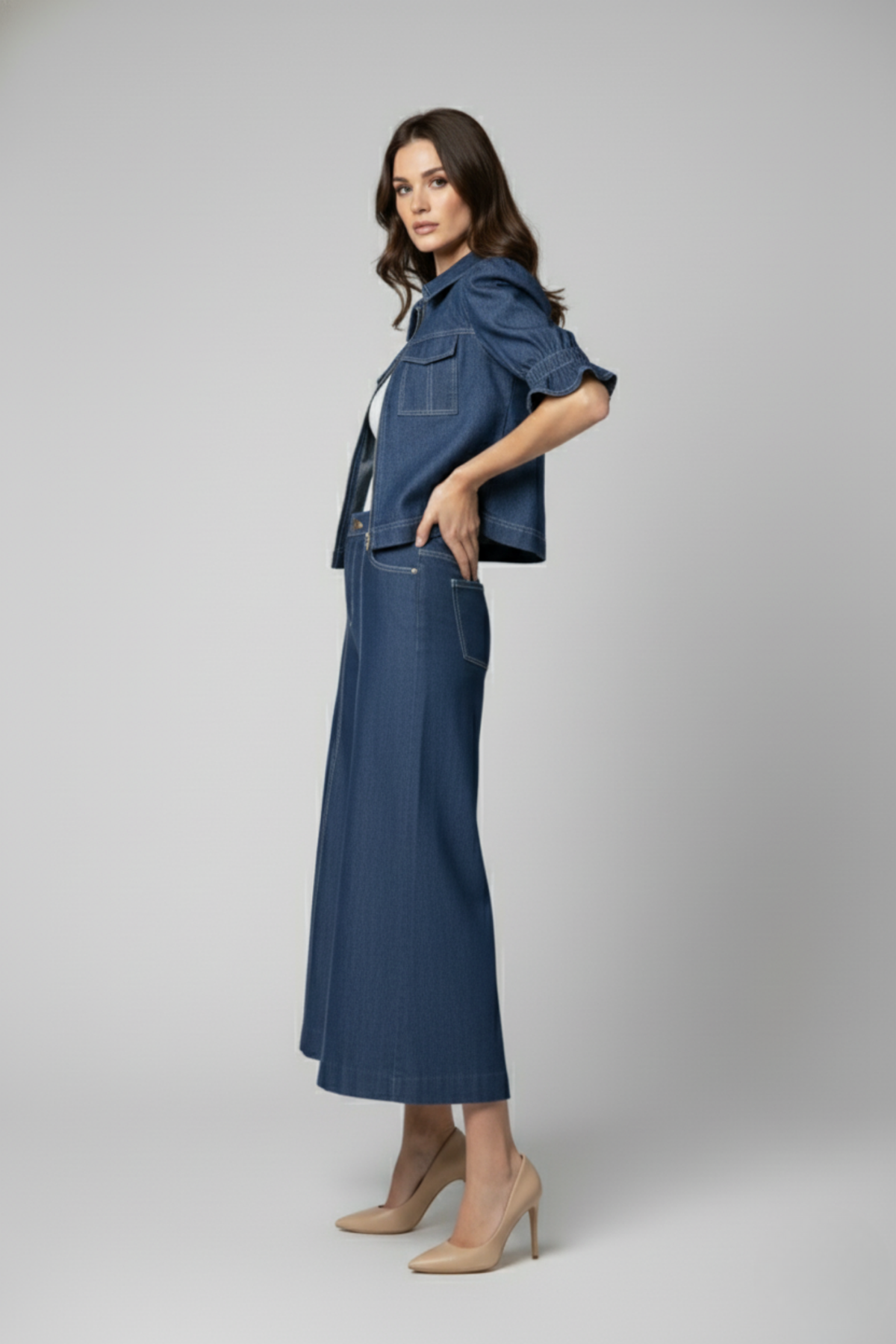 Vista lateral de la Casaca Campo en denim azul con mangas cortas voluminosas estilo balloon y silueta estructurada, combinada con pantalón de jean | Claudia Bertolero