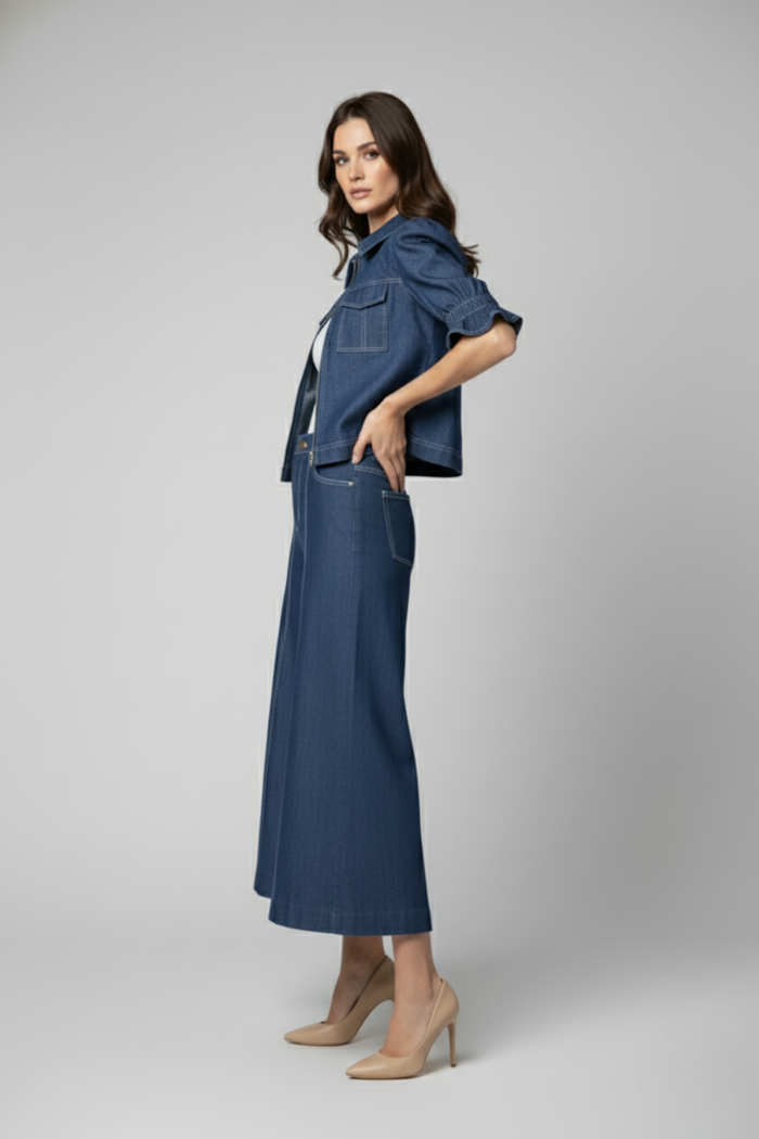 Vista lateral de la Casaca Campo en denim azul con mangas cortas voluminosas estilo balloon y silueta estructurada, combinada con pantalón de jean | Claudia Bertolero