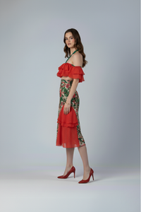 Falda Catalina midi en drill con estampado floral tropical y bobos de gasa roja en los laterales que añaden volumen y movimiento, vista lateral del diseño | Claudia Bertolero