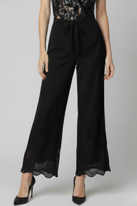 Pantalón Coulise negro en lino con cintura ajustable con jalador y detalle de broderí en la basta, vista frontal | Claudia Bertolero