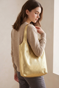 Modelo llevando bolso Milán color dorado de Claudia Bertolero elaborado en cuero de res con diseño amplio | Claudia Bertolero
