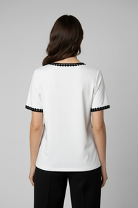 Polo Alma Mía blanco de manga corta con ribete de crochet negro en cuello y mangas, vista posterior | Claudia Bertolero