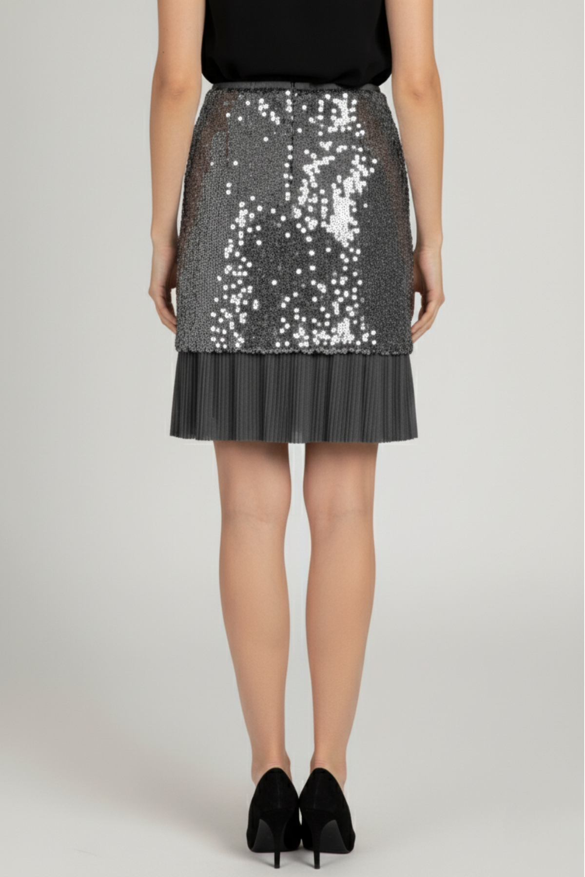 Falda Audrey corta en lentejuelas gris con cierre en la espalda y detalle inferior de gasa plisada, diseño estructurado sin elástico en la cintura | Claudia Bertolero