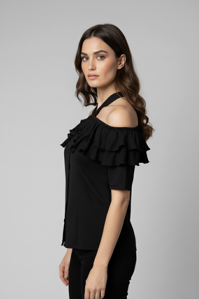 Vista posterior de la Blusa Catalina en seda negra con hombros descubiertos y cuello halter. El diseño resalta la espalda y las capas de bobos que rodean el escote con elegancia | Claudia Bertolero