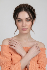 Primer plano de la Blusa Penélope con escote off shoulder y elástico fruncido. El estampado vichy en tono durazno resalta el estilo femenino y ligero de la prenda | Claudia Bertolero