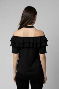 Vista posterior de la Blusa Catalina en seda negra con hombros descubiertos y cuello halter. El diseño resalta la espalda y las capas de bobos que rodean el escote con elegancia | Claudia Bertolero