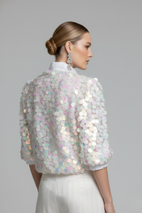 Vista posterior de blusa Sparkling blanca con mangas de tul bordadas con lentejuelas iridiscentes y silueta estructurada | Claudia Bertolero