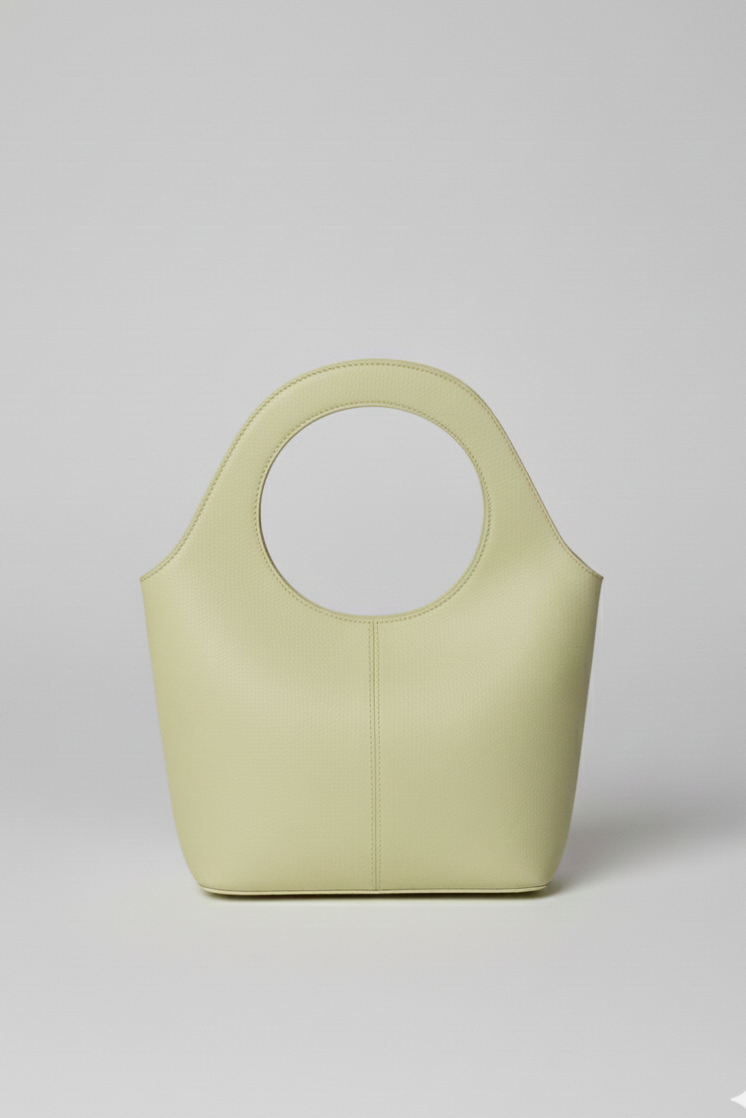 Cartera Milan chica de cuero color verde claro con diseño minimalista y asa circular | Claudia Bertolero