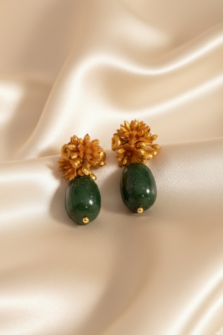 Pendientes Les Fleurs con flores doradas y piedra verde sobre fondo de seda | Claudia Bertolero